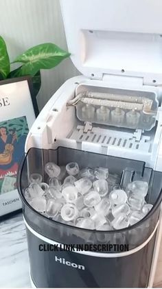 an ice bucket filled with water next to a book