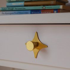 a close up of a drawer with books on top of it and a book shelf in the background