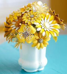 a white vase filled with yellow and white flowers