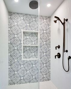 a bathroom with a shower head, mirror and tiled flooring in it's corner