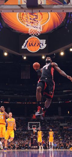 the basketball player is jumping up in the air to dunk the ball during a game