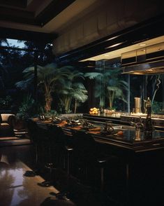 a dimly lit bar with lots of bottles and glasses on the counter in front of palm trees