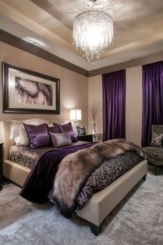 a bedroom with a bed, chair and chandelier hanging from the ceiling in front of purple drapes