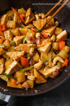 chicken and vegetable stir fry in a wok with chopsticks