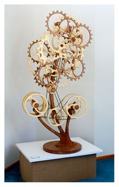 a wooden sculpture with gears on top of it