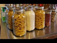 several jars filled with different types of pasta