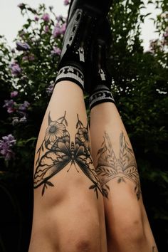 a woman's legs with tattoos and flowers on them