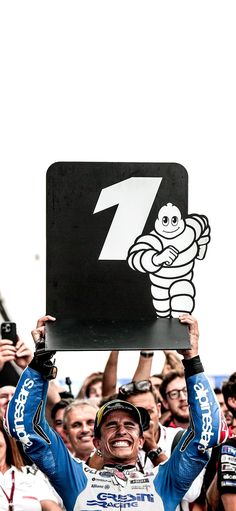 a man holding up a sign in front of a crowd