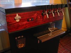 an old fashioned machine with four glasses on it's front and three taps on the back