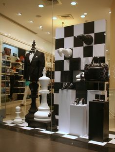 a black and white checkered floor in front of a store window with mannequins