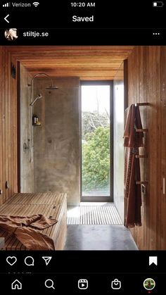 an open bathroom with wooden walls and floor to ceiling glass doors that lead out onto the outdoors