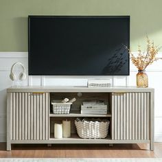 a flat screen tv sitting on top of a wooden entertainment center