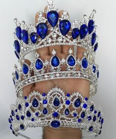 a hand holding a blue and white tiara