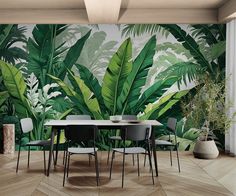 a dining room with a table and chairs in front of a wall mural that has green leaves on it