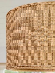 a wicker lamp shade hanging from a ceiling fixture in a living room or dining room