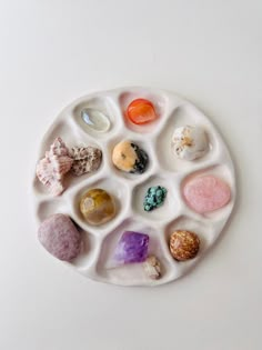 a white plate with different types of rocks and stones arranged in the shape of a circle