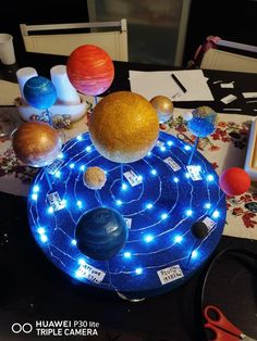 a table topped with an array of planets and other objects on it's surface