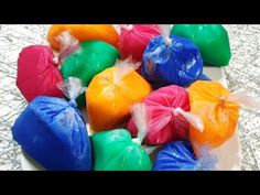 colorful candies are on a white plate with plastic wrappers around them and sitting on a silver tablecloth