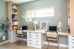 a desk with two chairs and a laptop on it in front of a window next to a potted plant