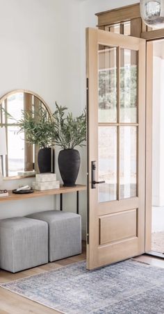 a living room with a couch and mirror on the wall next to an entryway