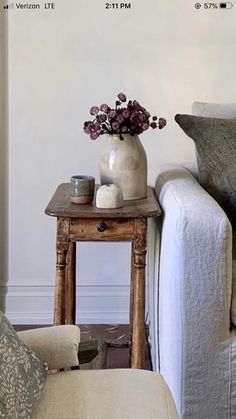 a living room with a couch, table and flowers on the coffee table next to it