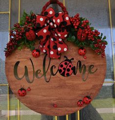 a welcome sign with ladybugs and berries