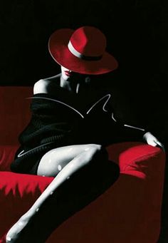 a woman sitting on top of a red couch wearing a red hat and black dress