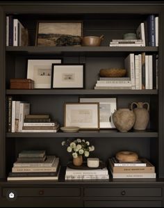 a book shelf with books and vases on it