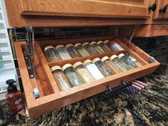 an open drawer in a kitchen filled with spices