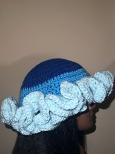 a woman wearing a blue and white crocheted hat