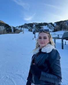 a woman standing on top of a snow covered slope