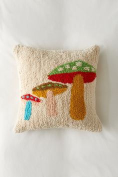 an embroidered pillow with colorful mushrooms on it