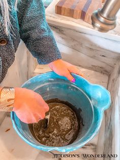 a woman is mixing something in a blue bowl