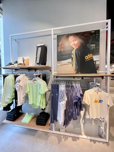 a display case with shirts and t - shirts on it's shelves in a store