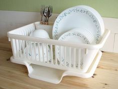 a white dish rack with plates and silverware in it