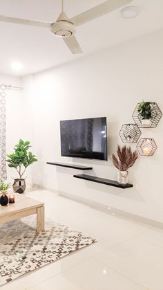 a living room filled with furniture and a flat screen tv mounted on the wall over a wooden coffee table