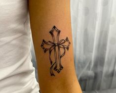 a woman with a cross tattoo on her arm