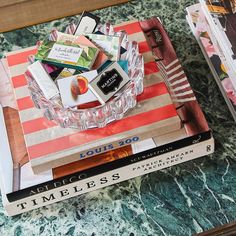 two books are stacked on top of each other in front of a marble countertop