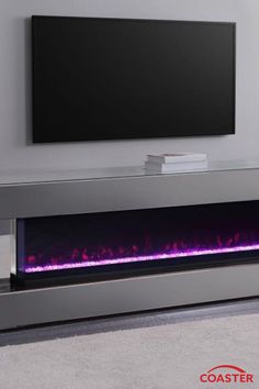 an electric fireplace with purple flames in front of a flat screen tv mounted on the wall