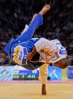 a man doing a handstand on the ground in front of a large crowd