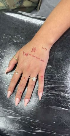 a woman's hand with two small tattoos on it