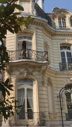 an ornate building with balconies and wrought iron railings on the top floor