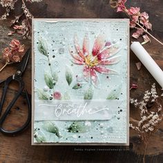 a close up of a card with flowers on it and scissors next to the card