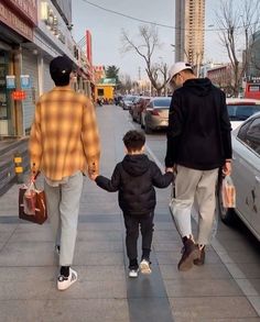 an older man and two young boys walking down the street