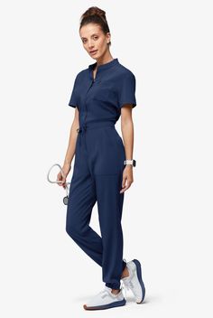 Now, this is modern. A jumpsuit! No easier way to get dressed – nothing to match and your top stays tucked in. Ours is so cute – a drawstring to add shape plus six functional pockets. The Easy Stretch Collection is designed for a modern look and easy fit. 4-way stretch performance fabric keeps you comfortable all shift long. • Modern fit • Open placket neckline • Concealed full-length front zipper • Drawstring waist • Total of 6 pockets • 2 roomy front patch pockets • 1 cellphone pocket • 2 back Fashionable Scrubs Woman, Nanny Uniform Modern, Scrub Jumpsuit, Medical Outfits Women, Modern Restaurant Uniforms, Nurses Uniform Modern, Scrubs Uniform Cute, Nurse Fashion Scrubs, Housekeeping Uniform