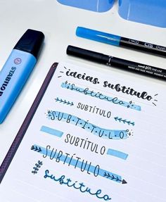 some type of writing on top of a white table with blue markers and pencils