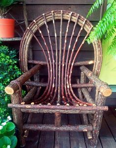 a wooden chair sitting on top of a wooden floor next to a potted plant