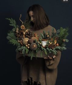 a woman holding a tray filled with christmas decorations