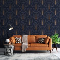 an orange leather couch in front of a blue wall with gold art deco fan pattern