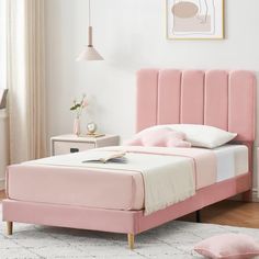 a bed with pink headboard and foot board in a white room next to a window